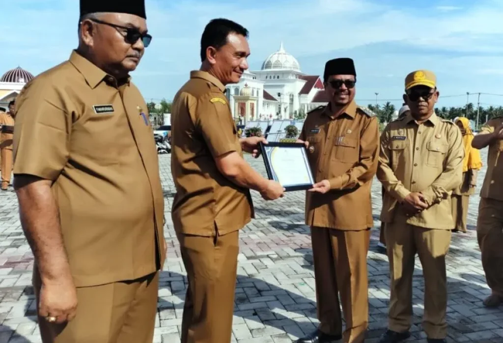 Foto: Pj Bupati Azwardi, AP, MSi, juga memberikan penghargaan khusus kepada Kepala Dinas Pendidikan dan Kebudayaan Kabupaten Aceh Utara Jamaluddin, SSos, MPd