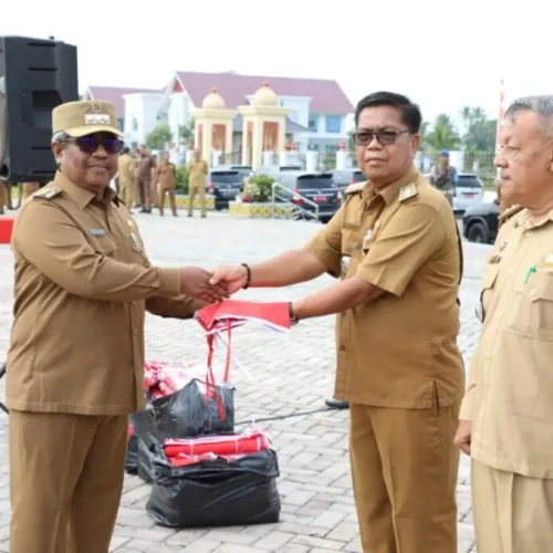 FOTO: Penjabat Bupati Aceh Utara Dr Drs Mahyuzar, MSi, menyerahkan Bendera kepada para Camat