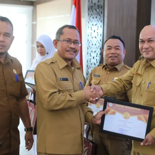 Foto: Kepala Dinas Kepemudaan, Olahraga dan Pariwisata (Disporapar) Aceh Utara, M Nasir., MSI (tengah) menyerahkan penghargaan