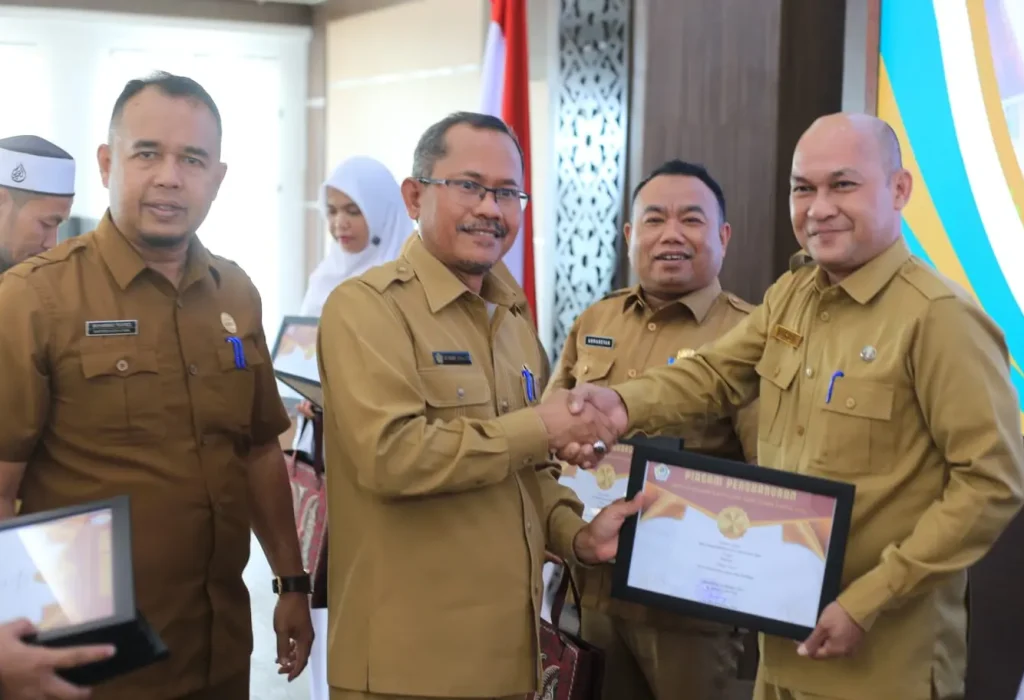 Foto: Kepala Dinas Kepemudaan, Olahraga dan Pariwisata (Disporapar) Aceh Utara, M Nasir., MSI (tengah) menyerahkan penghargaan