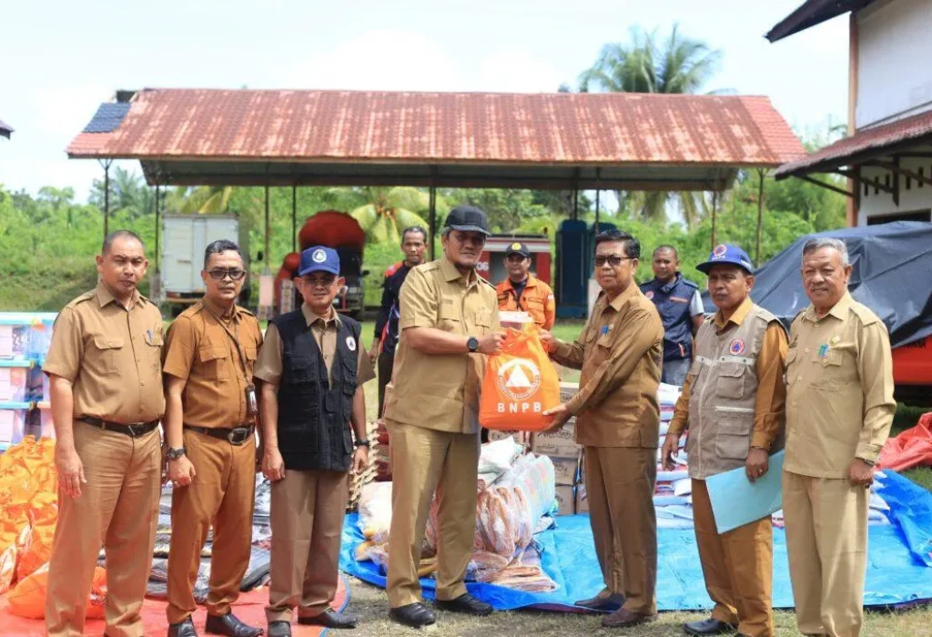 Foto: Plt Sekretaris Daerah Kabupaten Aceh Utara Dayan Albar, SSos, MAP, menyerahkan Simbolis Bantuan kepada Camat Pirak Timu