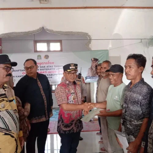 Foto: Penjabat (Pj.) Bupati Aceh Jaya, Dr. A. Murtala, M.Si, menyerahkan sertifikat hak atas Pendaftaran Tanah Sistematis Lengkap (PTSL) secara simbolis kepada masyarakat Desa Alue Pande, Kecamatan Panga
