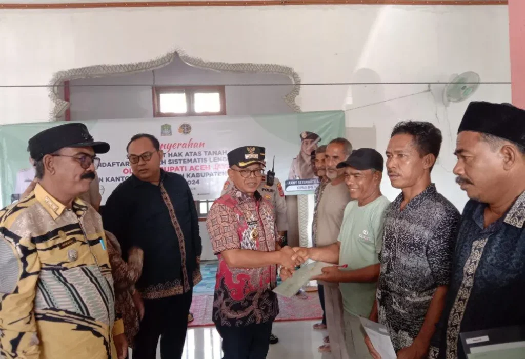 Foto: Penjabat (Pj.) Bupati Aceh Jaya, Dr. A. Murtala, M.Si, menyerahkan sertifikat hak atas Pendaftaran Tanah Sistematis Lengkap (PTSL) secara simbolis kepada masyarakat Desa Alue Pande, Kecamatan Panga