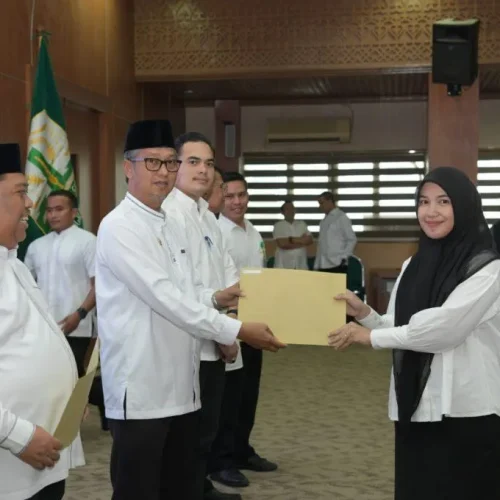Foto: Asisten Administrasi Umum Sekda Aceh Dr. H. Iskandar AP, S.Sos. M.Si menyerahkan Sk tenaga kontrak kepada salah satu tenaga kontrak pada biro Adpim di gedung serbaguna Kantor Gubernur, Jum'at 22 Maret 2024.