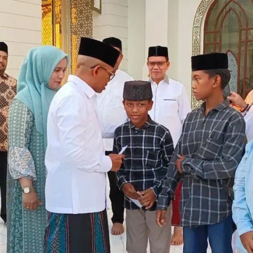 Foto: Penjabat Bupati Aceh Jaya, Dr. A. Murtala.,M.Si menyerahkan santunan kepada puluhan anak yatim didampingi Ketua TP PKK Ace Jaya, Mahdalena, SE, MSM