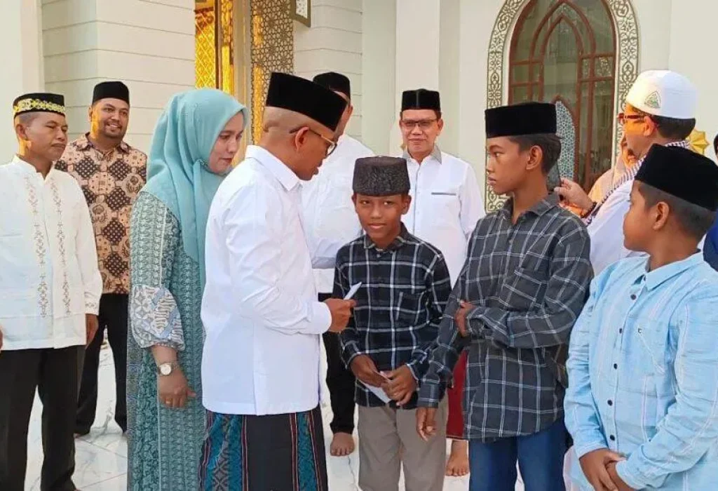 Foto: Penjabat Bupati Aceh Jaya, Dr. A. Murtala.,M.Si menyerahkan santunan kepada puluhan anak yatim didampingi Ketua TP PKK Ace Jaya, Mahdalena, SE, MSM
