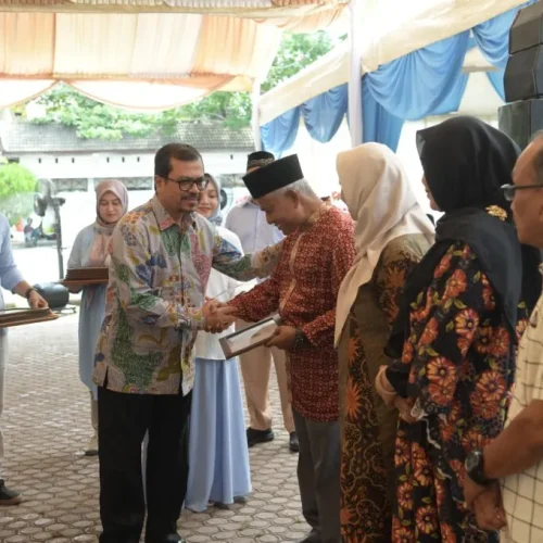 Foto: Pj. Sekda Aceh, Azwardi, AP, M.Si menyerahkan piagam penghargaan purna tugas kepada pegawai RSUZA di halaman RSUZA Banda Aceh,  20/4/2024
