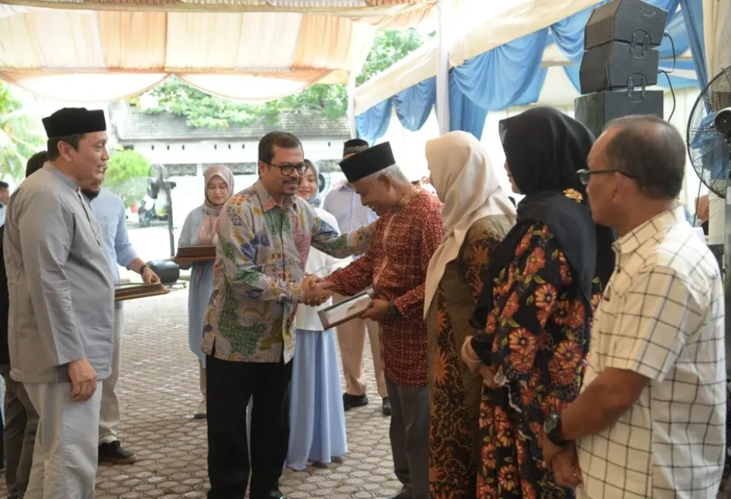 Foto: Pj. Sekda Aceh, Azwardi, AP, M.Si menyerahkan piagam penghargaan purna tugas kepada pegawai RSUZA di halaman RSUZA Banda Aceh,  20/4/2024