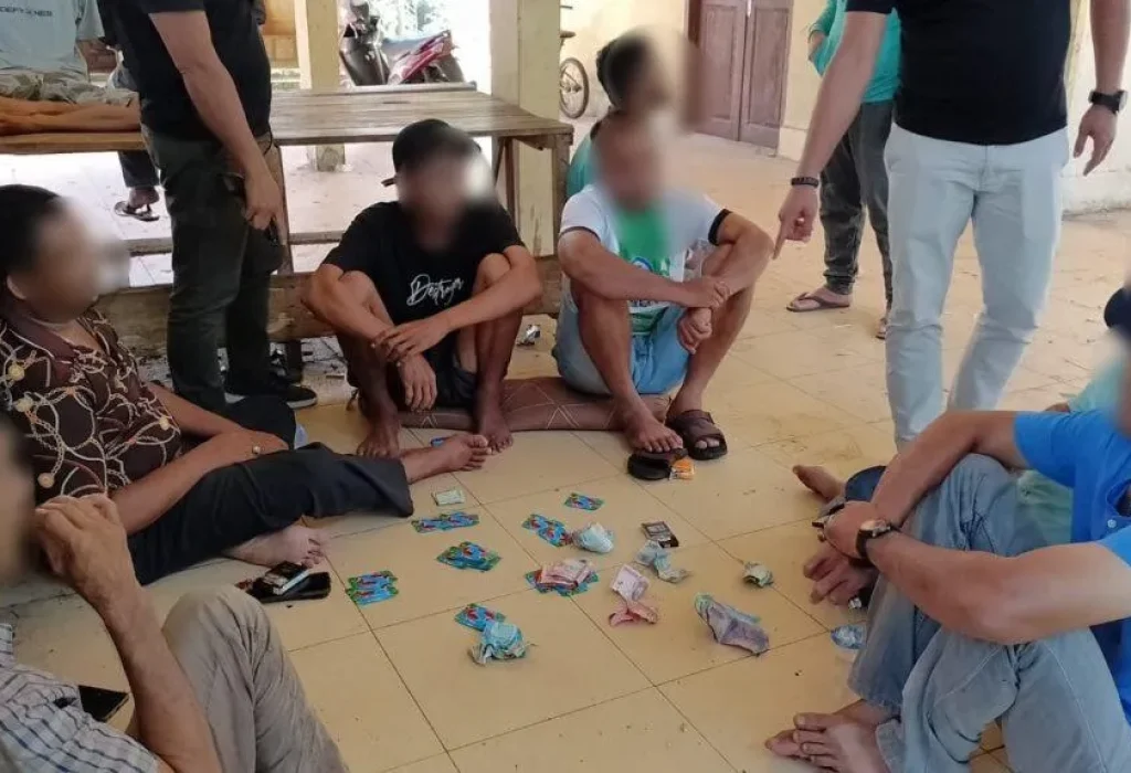 Foto: Personel Satreskrim Polres Nagan Raya menggerebek lokasi perjudian di pasar ikan Desa Kuta Baroe, Kecamatan Seunagan, Kabupaten Nagan Raya, Selasa, 23 April 2024. Dalam penggerebekan itu, polisi menangkap tujuh pelaku dan mengamankan barang bukti uang jutaan rupiah.