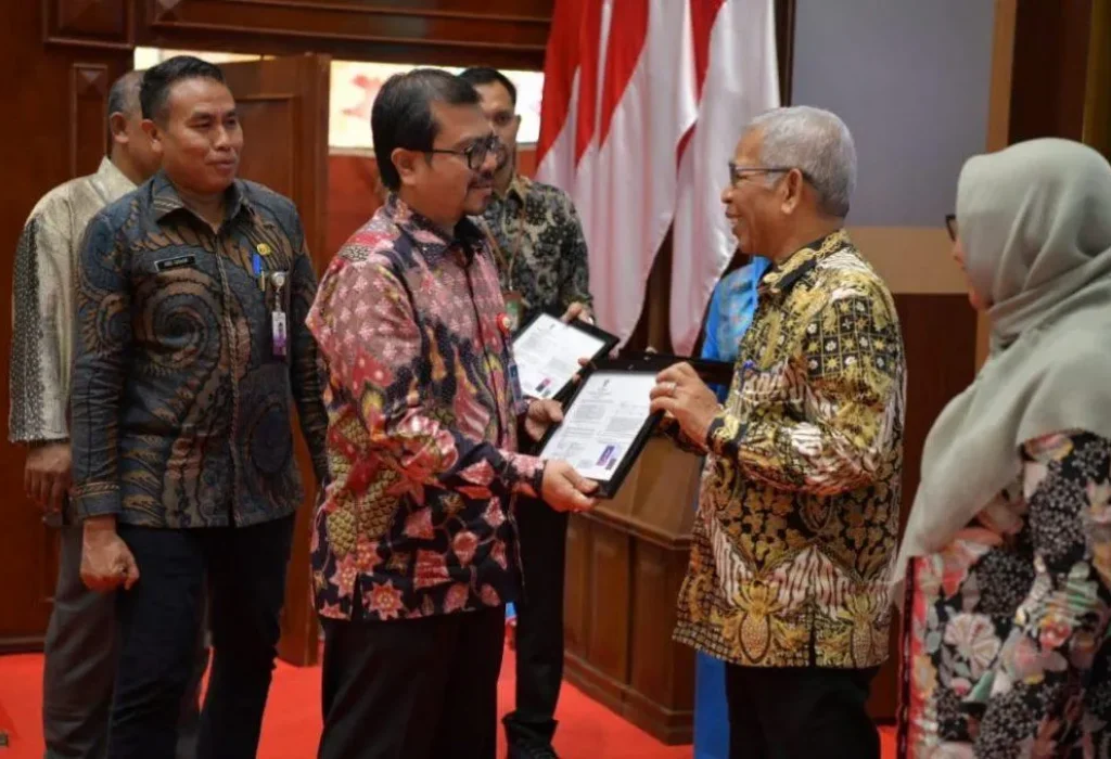 Foto: Pj. Sekda Aceh, Azwardi AP didampingi Kepala BKA, Abdul Qahar dan Kepala BKN Perwakilan Aceh Menyerahkan SK Pensiun pada pembukaan Sosialisasi Hak & Kewajiban Serta Wirausaha Pintar Bagi PNS Batas Usia Pensiun diLingkungan Pemerintah Provinsi Aceh di Anjong Monmata, Banda Aceh.