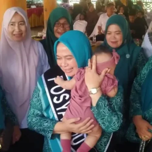 Foto: Pj Ketua TP PKK Aceh Utara Ny Awirdalina Mahyuzar, mengendong balitas usai melakukan timbang berat badan