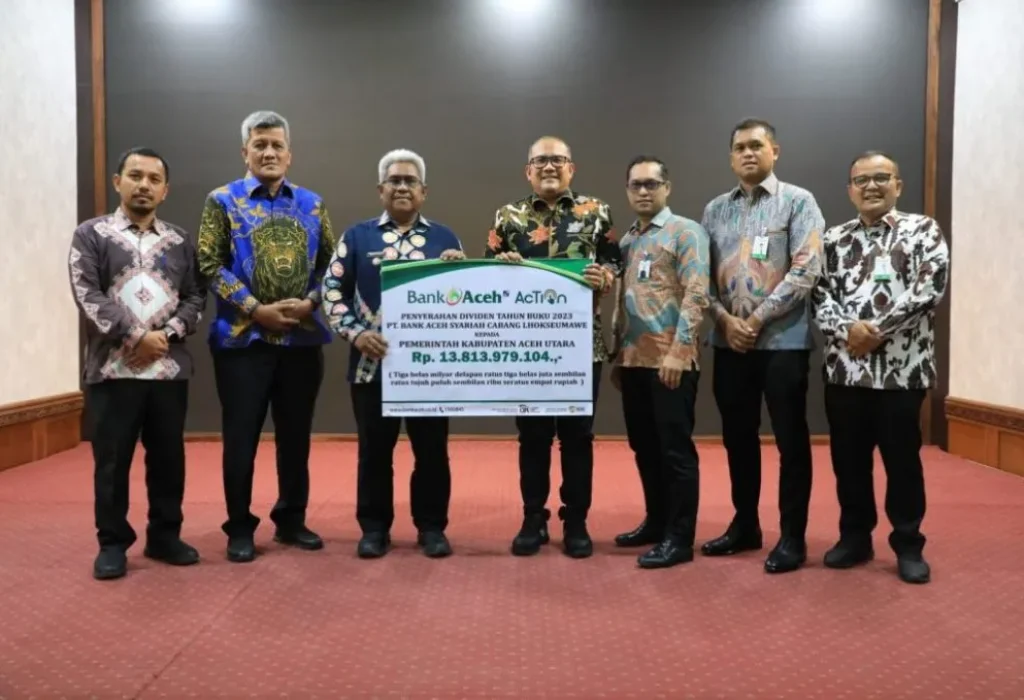 Foto:  Kepala Bank Aceh Syariah Cabang Lhokseumawe, Taufik Saleh menyerahkan dividen tahun buku 2023 sebesar Rp. 13.813.979.104 kepada Penjabat (Pj) Bupati Aceh Utara Dr. Drs. Mahyuzar MSI didampingi Pj Sekda Dayan Albar, S.Sos, MAP, Kamis, 13 Juni 2024.