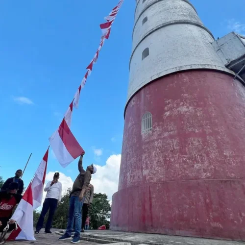 Foto: Kepala Badan Kesbangpol Aceh, Dedy Yuswadi bersama Kabid Bina Ideologi, Wawasan Kebangsaan Dan Karakter Bangsa, Munarwansyah mengibarkan Bendera Merah Putih di Mercusuar Willem's Torrent III, Pulo Breuh, Aceh Besar, Sabtu 6 Juli 2024.
