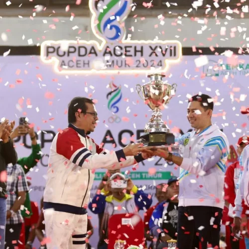 Foto: Penjabat Sekretaris Daerah Aceh, Azwardi AP, M.Si., atas nama PJ Gubernur Aceh menyerahkan piala bergilir kepada Kota Banda Aceh yang keluar sebagai juara umum  pada Pekan Olahraga Pelajar Daerah (POPDA) Aceh ke-XVII Tahun 2024, Di Gedung Idi Sport Center (ISC), Aceh Timur, Jumat, 12/7/2024.
