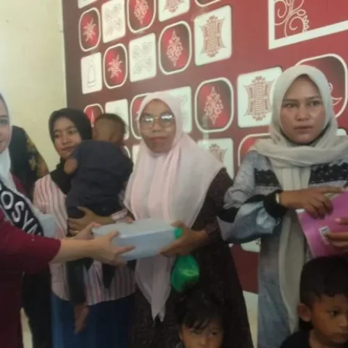 Foto: Pj. Ketua  TP PKK Aceh Utara Ny Awirdalina menyerahkan Paket Ikan Segar Kepada Warga Dewantara