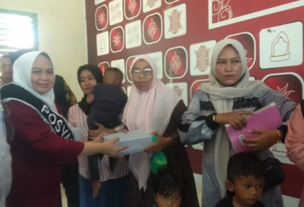 Foto: Pj. Ketua  TP PKK Aceh Utara Ny Awirdalina menyerahkan Paket Ikan Segar Kepada Warga Dewantara