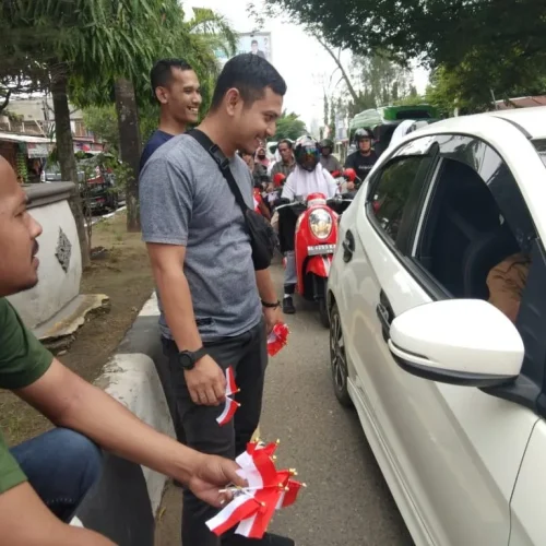 Foto: sejumlah Jurnalis di aceh Utara mebagaikan bendera secara gratis bagi pengendara
