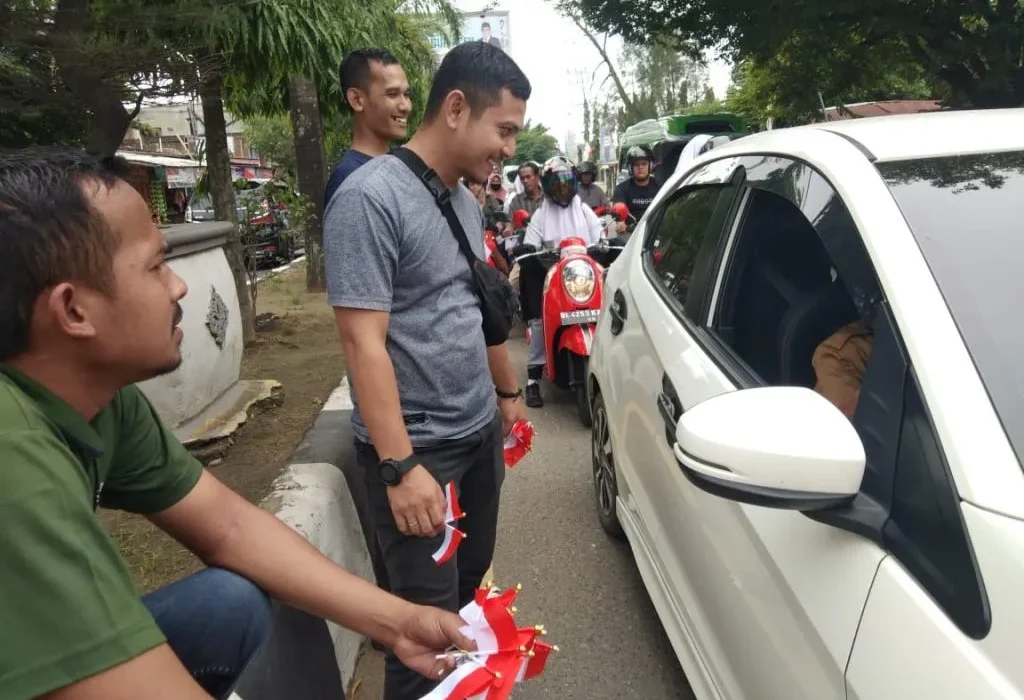 Foto: sejumlah Jurnalis di aceh Utara mebagaikan bendera secara gratis bagi pengendara