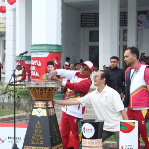 Foto: Pj. Bupati Aceh Jaya, Dr. A. Murtala menyalakan kembali Api untuk diserahkan kembali kepada pelari kirab Api PON XXI di halaman Kantor Bupati Aceh Jaya, 27/8/2024