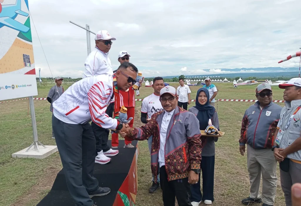 Foto: Anggota DPD RI asal Aceh H Sudirman, SE, alias Haji Uma turut menghadiri Upacara Penghormatan Pemenang (UPP) cabor terbang layang PON XXI Aceh - Sumut, dan berkenan mengalungkan medali kepada para pemenang, Senin, 16 September 2024.